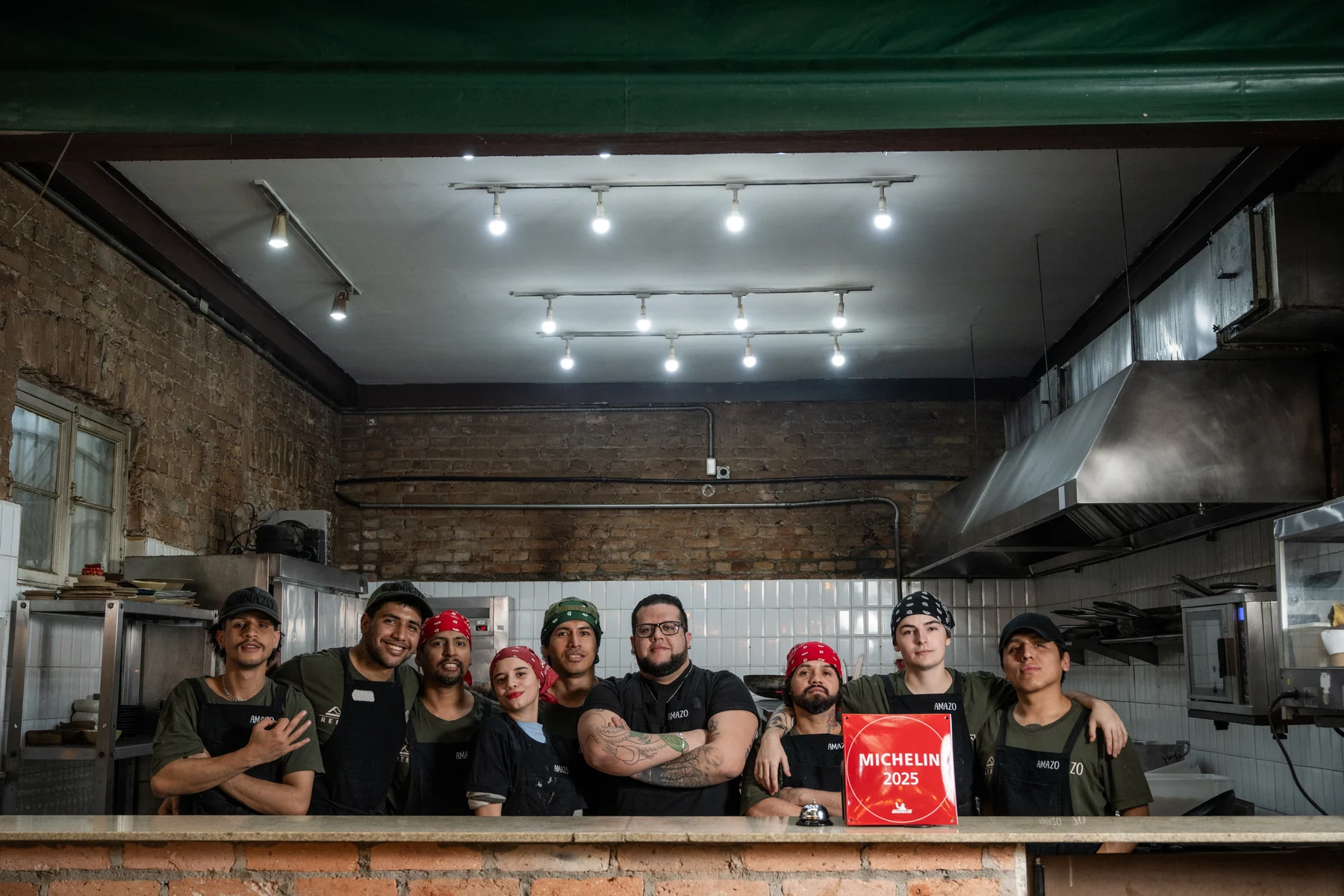 Equipe AMA.ZO na cozinha com placa Michelin